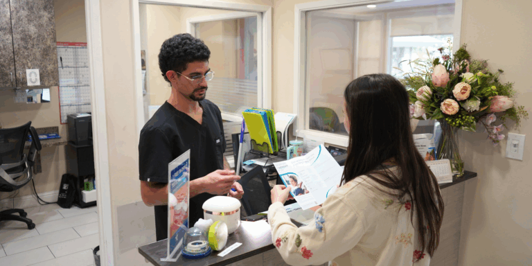 An employee at Smile Center Silicon Valley explains the Clerri Dental Membership Plan benefits to a patient.