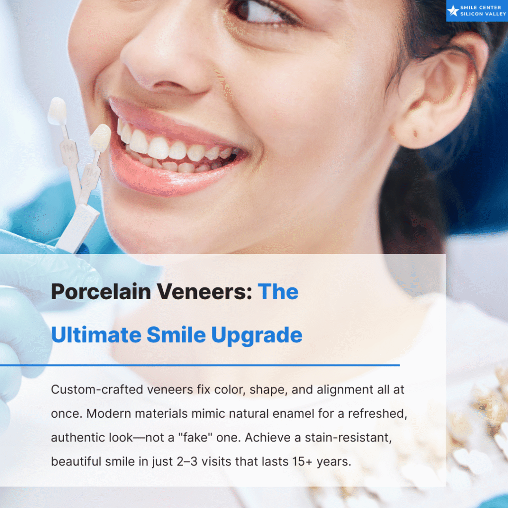 A close-up of a smiling woman at a dentist's office with a tooth shade guide, highlighting how porcelain veneers mimic natural enamel.